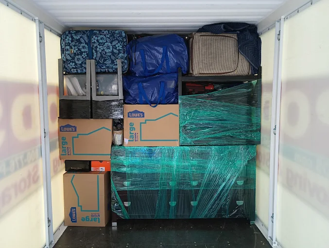 A moving truck with wrapped furniture and stacked boxes arranged tightly for transport.