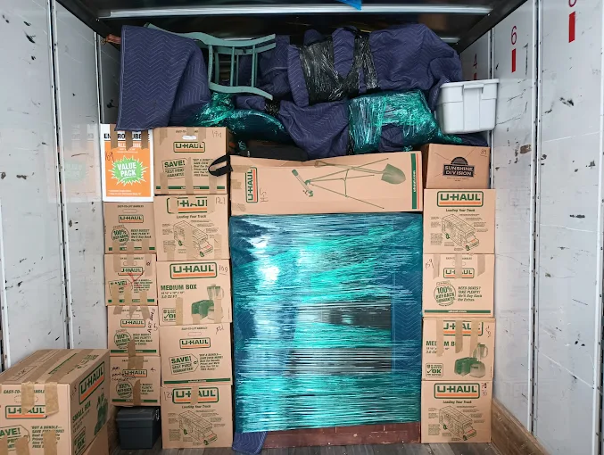 Another packed truck with boxed household items and protected furniture loaded in an organized way.